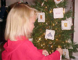 Anna hanging Jesse tree ornaments